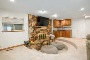 Living room featuring light colored carpet, a fireplace, and recessed lighting
