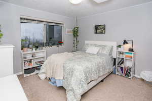 Bedroom with light carpet and a textured ceiling