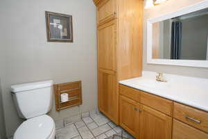 Bathroom with vanity, light tile patterned floors, and curtained shower