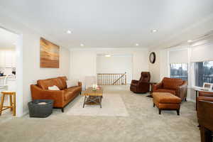 Living area with light colored carpet, recessed lighting, and crown molding