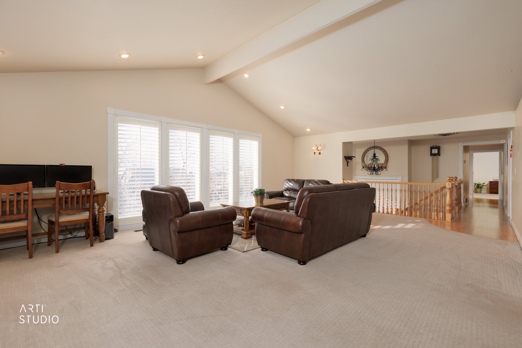 Living area with light colored carpet, recessed lighting, and beam ceiling