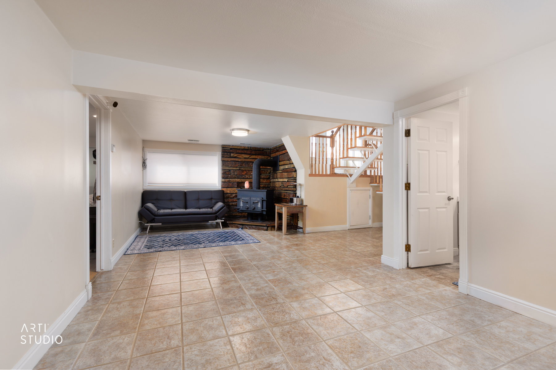 Living area with a wood stove and light tile patterned floors