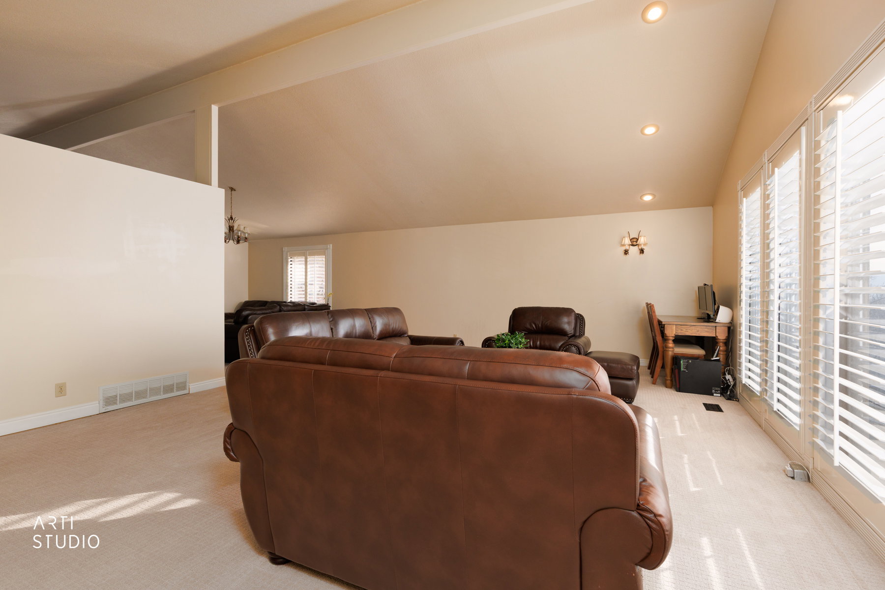 Living area featuring lofted ceiling with beams, carpet flooring, and recessed lighting