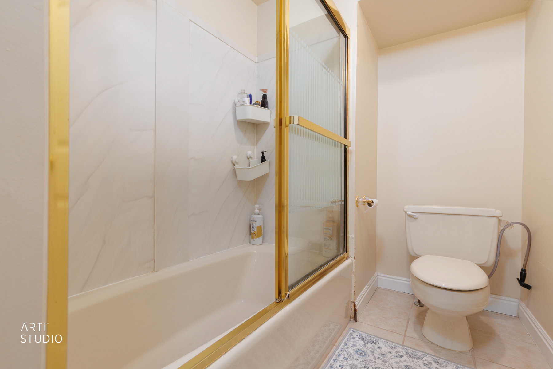 Full bathroom featuring light tile patterned floors and shower / bath combination with glass door