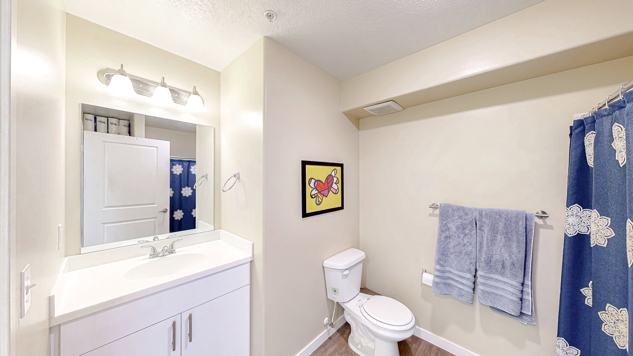 Full bathroom with vanity, a shower with curtain, a textured ceiling, and light wood-type flooring