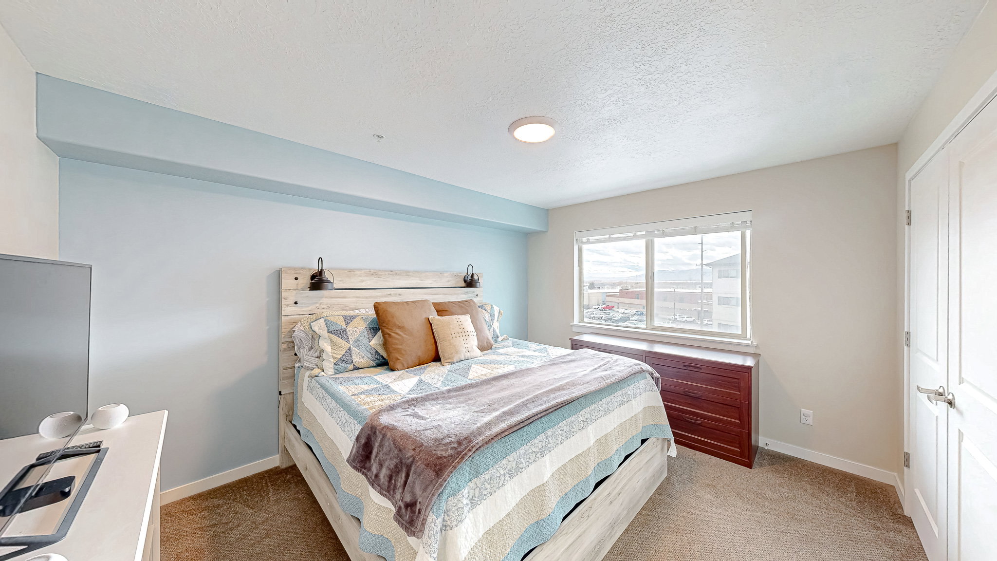 Bedroom featuring a closet, light colored carpet, and a textured ceiling