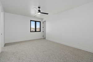 Upstairs bedroom with light carpet and ceiling fan