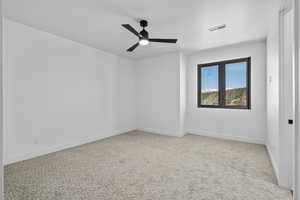 Upstairs bedroom with light carpet and ceiling fan