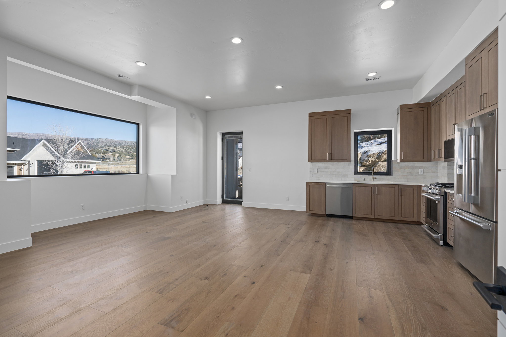ADU Kitchen with high end appliances, wood finish cabinetry, dark wood-style floors, decorative backsplash, and recessed lighting