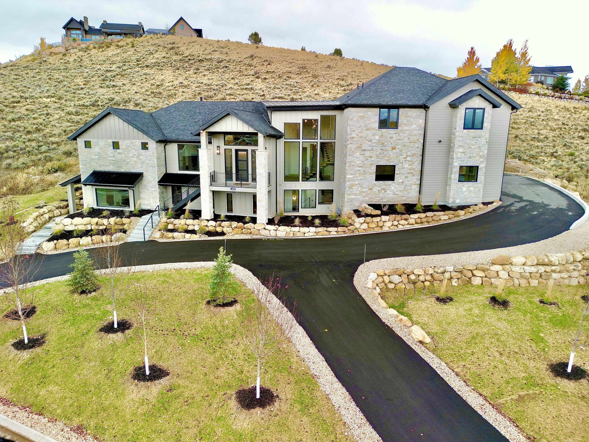 View of front of house with stone siding and a balcony