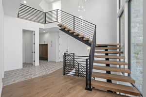 Stairs featuring parquet flooring and a high ceiling