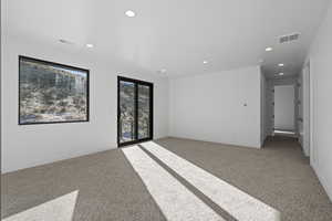 Upper level family room with light colored carpet and recessed lighting