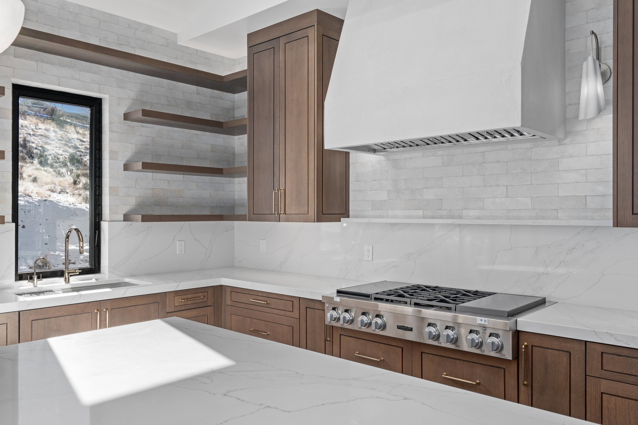 Kitchen with light stone countertops, stainless steel gas cooktop, backsplash, and open shelves