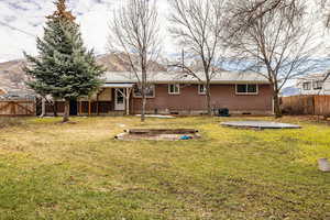 Back of house featuring a fenced backyard, a patio area, brick siding, and a gate