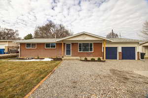 Ranch-style house featuring driveway, a garage, and brick exterior