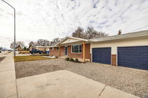 View of front of property with a porch, brick siding, an attached garage