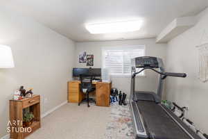 Home office with light carpet and baseboards