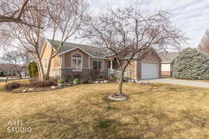 View of front of house with driveway, brick siding, a garage, and a front lawn