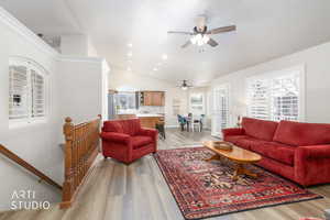 Living area featuring light wood finished floors, vaulted ceiling, and recessed lighting