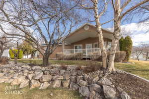 View of front of property with a porch, stucco siding, and a front lawn