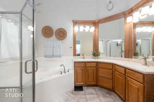 Bathroom featuring double vanity, a stall shower, a bath, and light tile patterned flooring