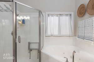 Full bathroom featuring a stall shower and a tub with jets