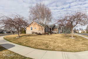 View of home's exterior featuring a lawn, a residential view, an attached garage, and stone siding