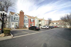 View of front facade featuring a residential view, uncovered parking, and a chimney