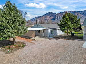 View of front of house featuring a mountain view, a patio area, and driveway
