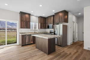 Kitchen with dark wood finish cabinets, stainless steel appliances, dark wood-style floors, a center island, and recessed lighting