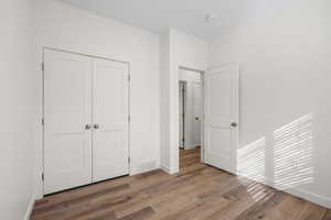 Unfurnished bedroom featuring light wood-style flooring and a closet