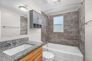 Bathroom with vanity, shower / washtub combination, and a textured ceiling