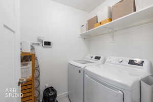 Laundry room featuring washer and clothes dryer and baseboards