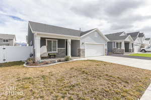 Craftsman house with covered porch, a garage, a gate, concrete driveway, and stone siding