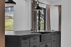 Kitchen view of dark stone countertops and decorative light fixtures