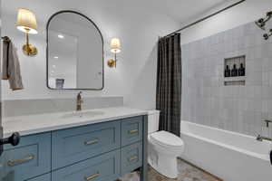 Bathroom with vanity, shower / tub combo, and light tile patterned flooring