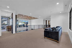 Sitting room with light colored carpet and recessed lighting