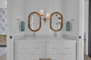 Bathroom featuring double vanity and carpet flooring