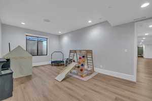 Playroom with recessed lighting and light wood-style flooring