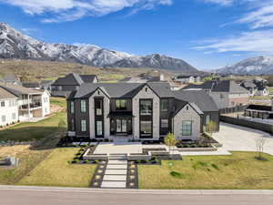 View of front of property with a residential view, a mountain view, a front lawn, and brick siding