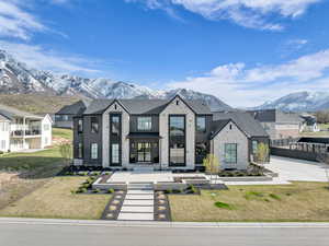 View of front of property featuring a mountain view, a front lawn, and a residential view