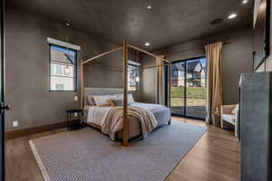 Bedroom featuring access to outside, wood finished floors, recessed lighting, and multiple windows