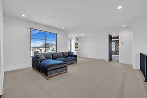 Living room with light colored carpet and recessed lighting