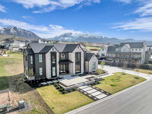 View of front of property with a residential view, a mountain view, and a front lawn