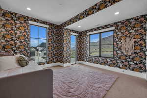 Unfurnished bedroom with recessed lighting, carpet flooring, a mountain view, and wallpapered walls