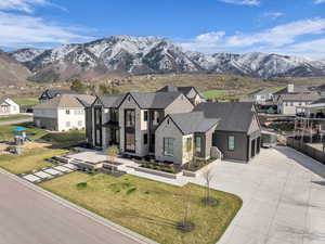 French country inspired facade featuring a residential view, a mountain view, concrete driveway, and a front lawn