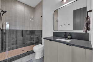 Full bathroom featuring vanity, a stall shower, and tile patterned flooring