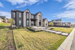Rear view of house featuring a lawn and a residential view