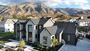 View of front facade featuring a residential view, stone siding, a mountain view, and a standing seam roof