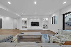 Living area featuring light wood-style floors and recessed lighting